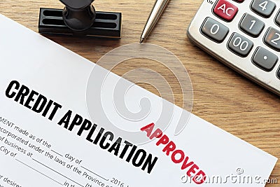 Approved credit application form lay down on wooden desk with ru Stock Photo