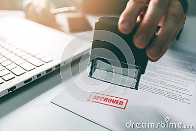 Approved stamp - businessman stamping document in office Stock Photo