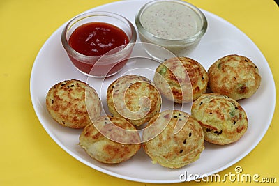 Appum or Appe, Appam or Mixed dal or Rava Appe served with green and red chutney. A Ball shape popular south Indian breakfast dish Stock Photo