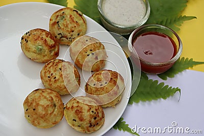 Appum or Appe, Appam or Mixed dal or Rava Appe served with green and red chutney. A Ball shape popular south Indian breakfast dish Stock Photo