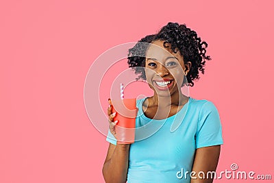 Appy young smiling woman holding a drinking cup with straw Stock Photo