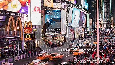 Apr 4, 2019: Crowd of people walking, car and taxi traffic transportation, and advertisement at night in Times Square Editorial Stock Photo