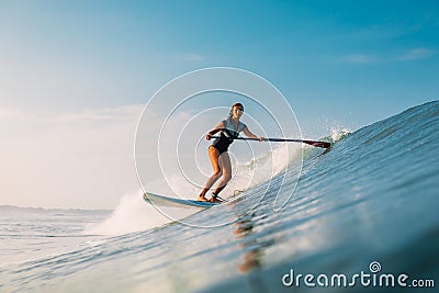 April 12, 2019. Bali, Indonesia. Stand Up Paddle surfer ride on ocean wave. Stand Up Paddle surfing at waves in Bali Editorial Stock Photo