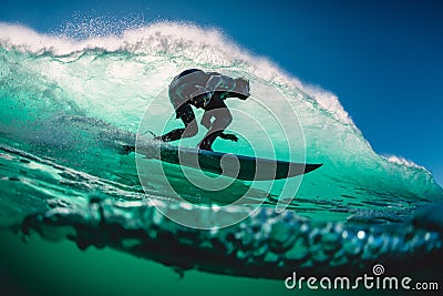 April 18, 2019. Bali, Indonesia. Surfer ride on barrel wave. Professional surfing at big waves in Padang Padang Editorial Stock Photo