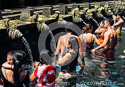 23 April, 2016, Bali, Indonesia - woman at the holy spring water is praying at Pura Tirtha Empul temple Editorial Stock Photo