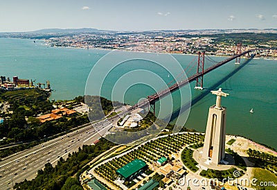 April of 25 bridge in Lisbon, crossing the Tagus River and Statue of Jesus Stock Photo