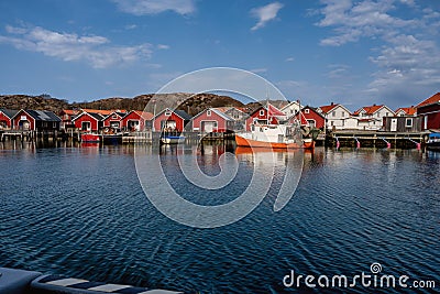 A picturesque fishing village on the Swedish West coast. Traditional red sea huts and a blue sky in the background Editorial Stock Photo