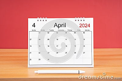 The April monthly desk calendar for 2024 year and pen on wooden table with red color background Stock Photo