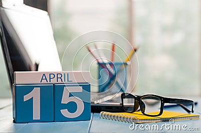 April 15th. Day 15 of month, calendar on business office background, workplace with laptop and glasses. Spring time Stock Photo