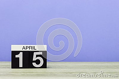 April 15th. Day 15 of month, calendar on wooden table and purple background. Spring time, empty space for text Stock Photo