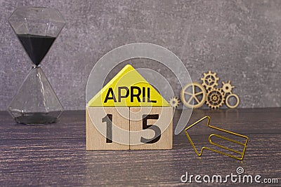 April 15th. Day 15 of month, calendar on wooden table and turquoise background. Stock Photo