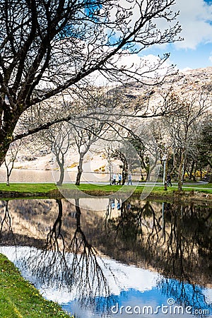 People walking towards Saint Finbarr`s Oratory, a chapel built on an island in Gougane Barra, a very serene and beautiful place. Editorial Stock Photo