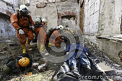 A group of rescuers provide first aid to the victim during the collapse of the building. Editorial Stock Photo