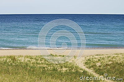 Aqua blur waters in warm summer michigan with dune grass and pat Stock Photo