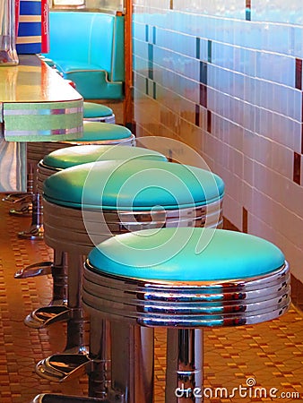 Aqua and chrome diner counter stools in row Stock Photo