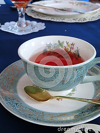 Aqua and gold scroll tea cup with flowers on saucer Stock Photo