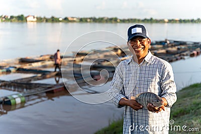 Aquaculture farmers hold quality tilapia yields in hand, guaranteeing integrity in organic bio-aquaculture. Tilapia Farming Stock Photo