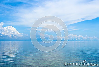 Aquatic seascape with distant island and blue sky. Relaxing sea view with still seawater. Stock Photo