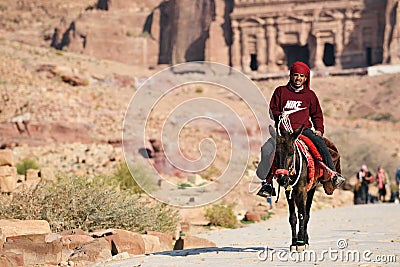 Arab bedouin guide riding in the ancient city of Petra, Jordan Editorial Stock Photo