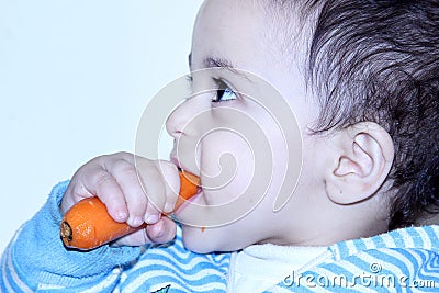 Arab egyptian baby girl eating carrot Stock Photo