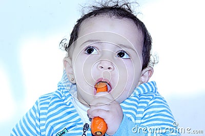 Arab egyptian baby girl eating carrot Stock Photo