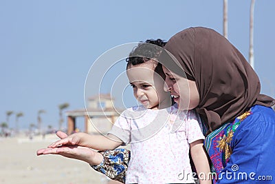 Arab egyptian muslim mother with her baby girl on beach in egypt Stock Photo