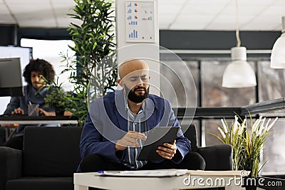 Arab executive manager checking financial data on tablet Stock Photo