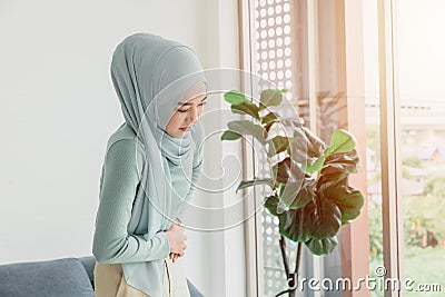 Arab Islam Women stomach ache serious cramps, abdominal pain from menstruation or period health problem expression Stock Photo
