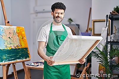 Arab man at art studio winking looking at the camera with sexy expression, cheerful and happy face Stock Photo