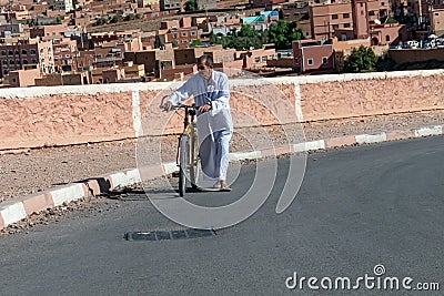 Arab man riding a bicycle in Boumalne Dades.Morocco. October 2019 Editorial Stock Photo