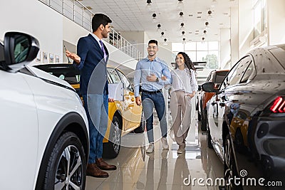 Arab man sales assistant giding young family by showroom Stock Photo