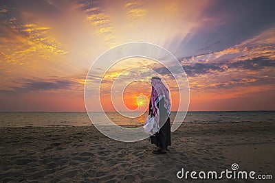 An arab old man standing in Fanateer beach with sunrise background. Al Jubail City -Saudi Arabia Stock Photo