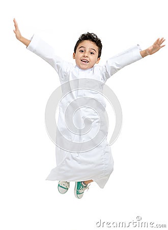 Arab Saudi boy jumping high with a big smile and open eyes Stock Photo