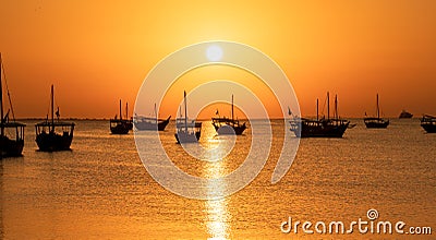 Arab traditional dhows in the shore during the sunrise in Qatar Stock Photo