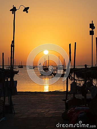 Arab traditional dhows in the shore during the sunrise in Qatar Stock Photo