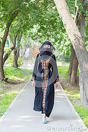 Arab woman national dress walks along a European. Stock Photo