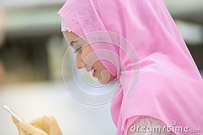 Arabian business woman smiling happy to use cell phone and modern business city background Stock Photo