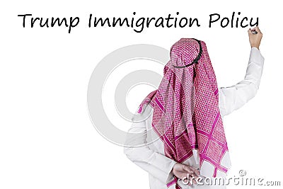 Arabian businessman writes Trump Immigration Policy word Editorial Stock Photo