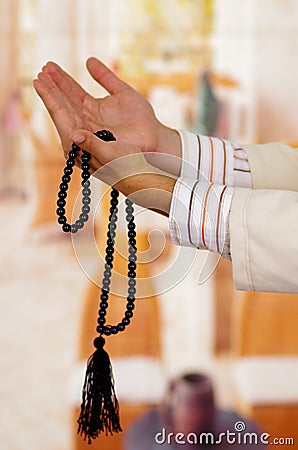 Arabian guy praying to his god and holding a masbaha Stock Photo