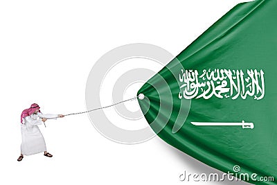 Arabian person pulls Saudi Arabia flag Stock Photo