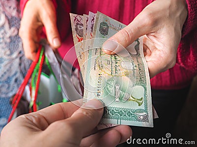 Arabic coins of dirhams. Curled banknotes in his hands. Stock Photo