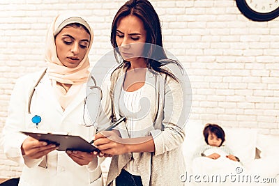 Arabic Doctor`s Appointment Mother with Sick Son Stock Photo