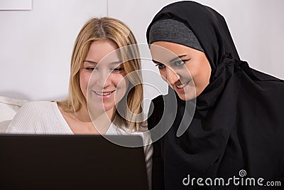 Arabic and european women watching Stock Photo