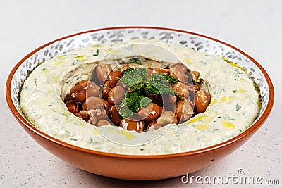 Arabic food Hummus with parsley in a traditional bowl. Stock Photo