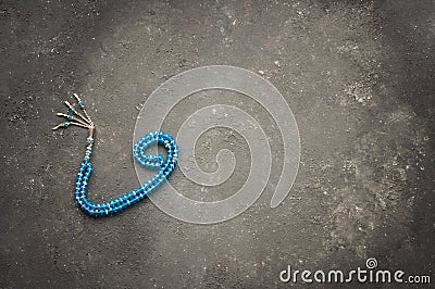 Arabic letter wav made with blue rosary on gray rustic background Stock Photo