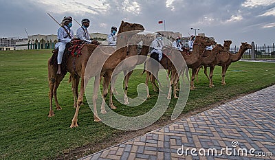 Arabic men in Traditional costume riding camels and standing in front of the Amiri diwan in Doha Qatar Editorial Stock Photo