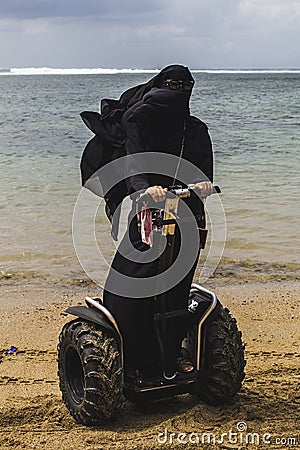 An arabic woman is riding a segway on a beach Editorial Stock Photo