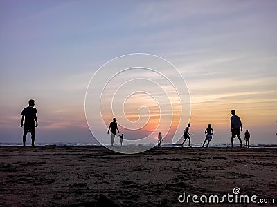 Boys playing football on the beach, beautiful sunset in background Editorial Stock Photo