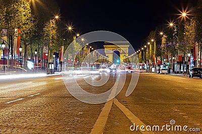 Arc de triomphe in Paris, France during rush hour at night. Traffic lights, tourist attraction Stock Photo