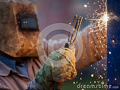 Arc welder worker in protective mask welding metal construction Stock Photo